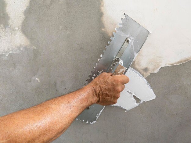 worker puts finishing layer stucco wall using plastering trowel_259266 4584